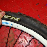 Lift tire up and out to remove tire bead from rim